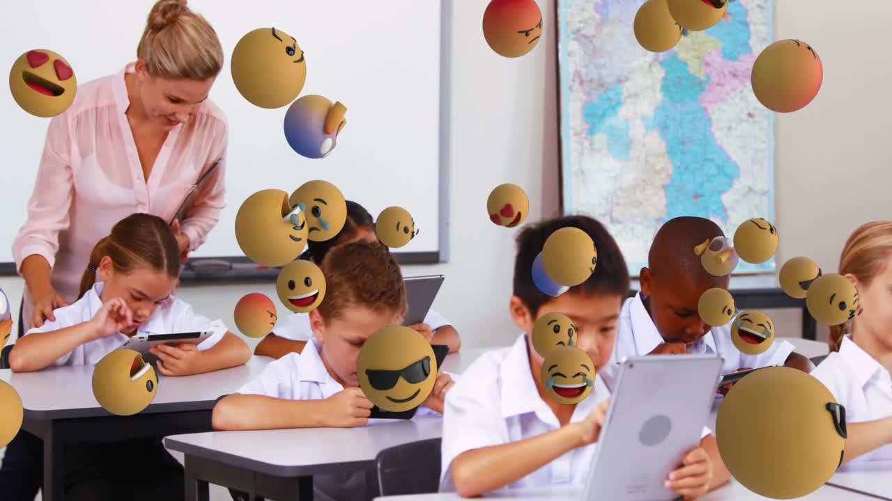 Animation of emoticons floating over diverse female teacher helping students with digital tablet