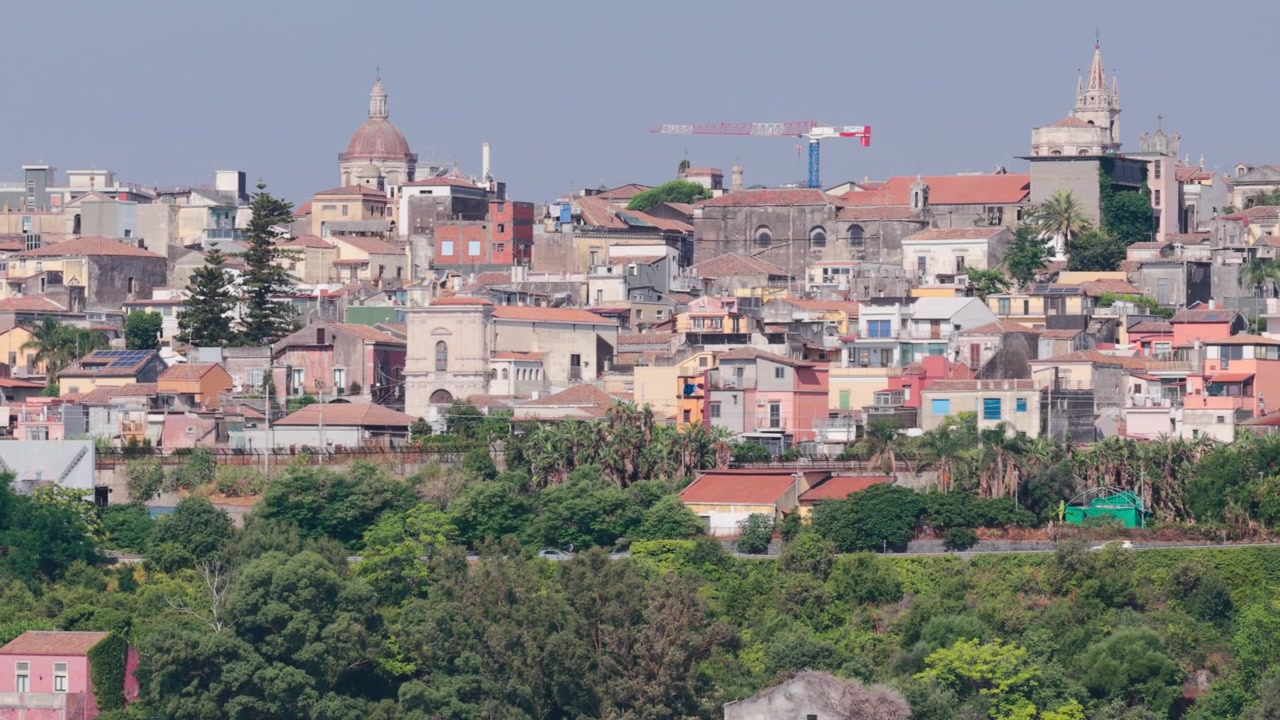 Ampia veduta aerea panoramica della SS114, una strada panoramica lungo scogliere di lava nera basaltica e edifici colorati con vista sullo skyline di Acireale, vicino a Catania, Sicilia, Italia, vicino all'Etna sulla costa ionica