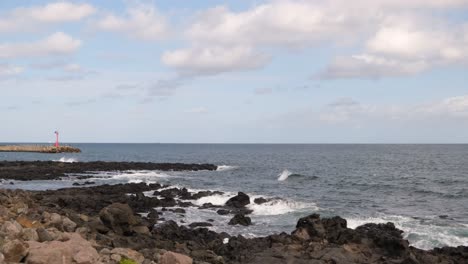 black volcanic rocks and ocean water on coast of jeju island in korea