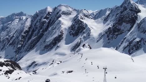 Drone-footage,-aerial-view-of-ski-resort-in-sunny-Austrian-Alps