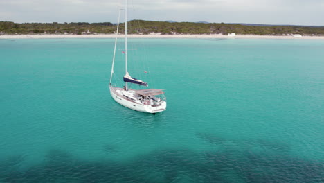 Aerial-View-Of-Sailboat-Sailing-In-The-Blue-Ocean-In-Mallorca,-Spain