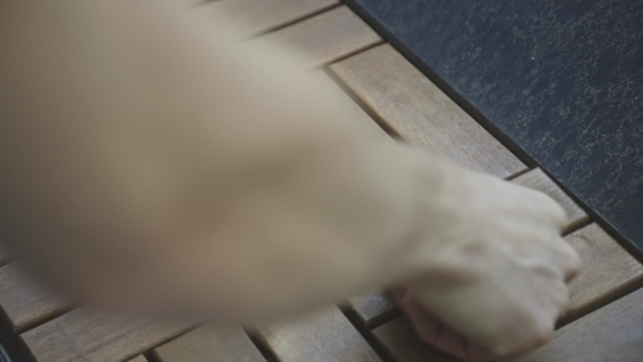 Person lægger træterrassefliser i haven