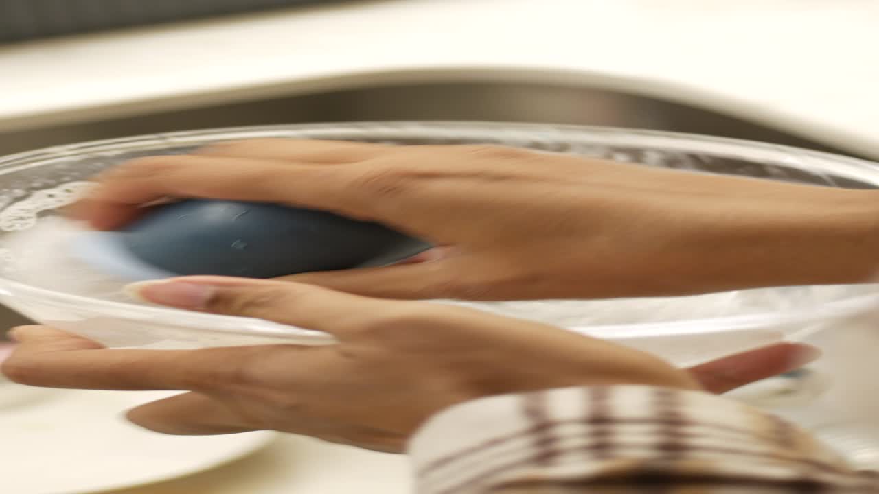 Washing dishes with sponge