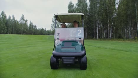 golfers in a cart on a rainy day