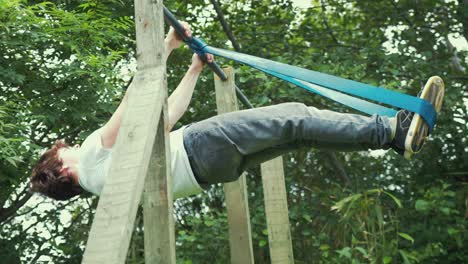 Joven-Realizando-Entrenamiento-De-Fuerza-De-Palanca-Frontal-Con-Banda-De-Resistencia-Gimnasio-Al-Aire-Libre-En-Casa