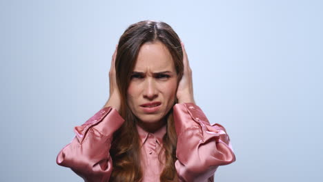 Exhausted-businesswoman-holding-hands-on-head-in-studio.-Woman-having-headache