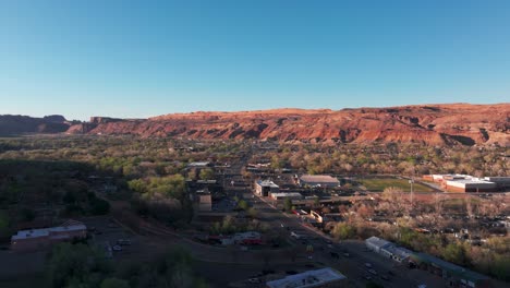 Fasting-panning-the-rising-drone-shot-over-main-street-and-downtown-Moab,-Utah