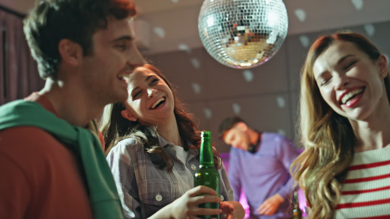 People enjoy disco party at home close up. Excited friends dancing together