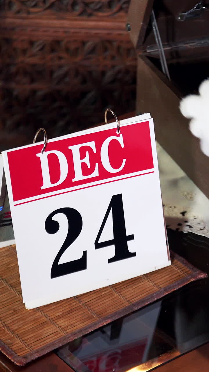 Santa Claus flips a calendar to December 24th, Christmas Eve