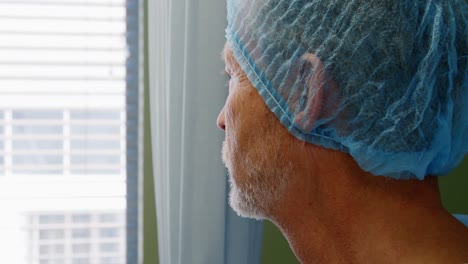 Thoughtful-doctor-standing-near-window