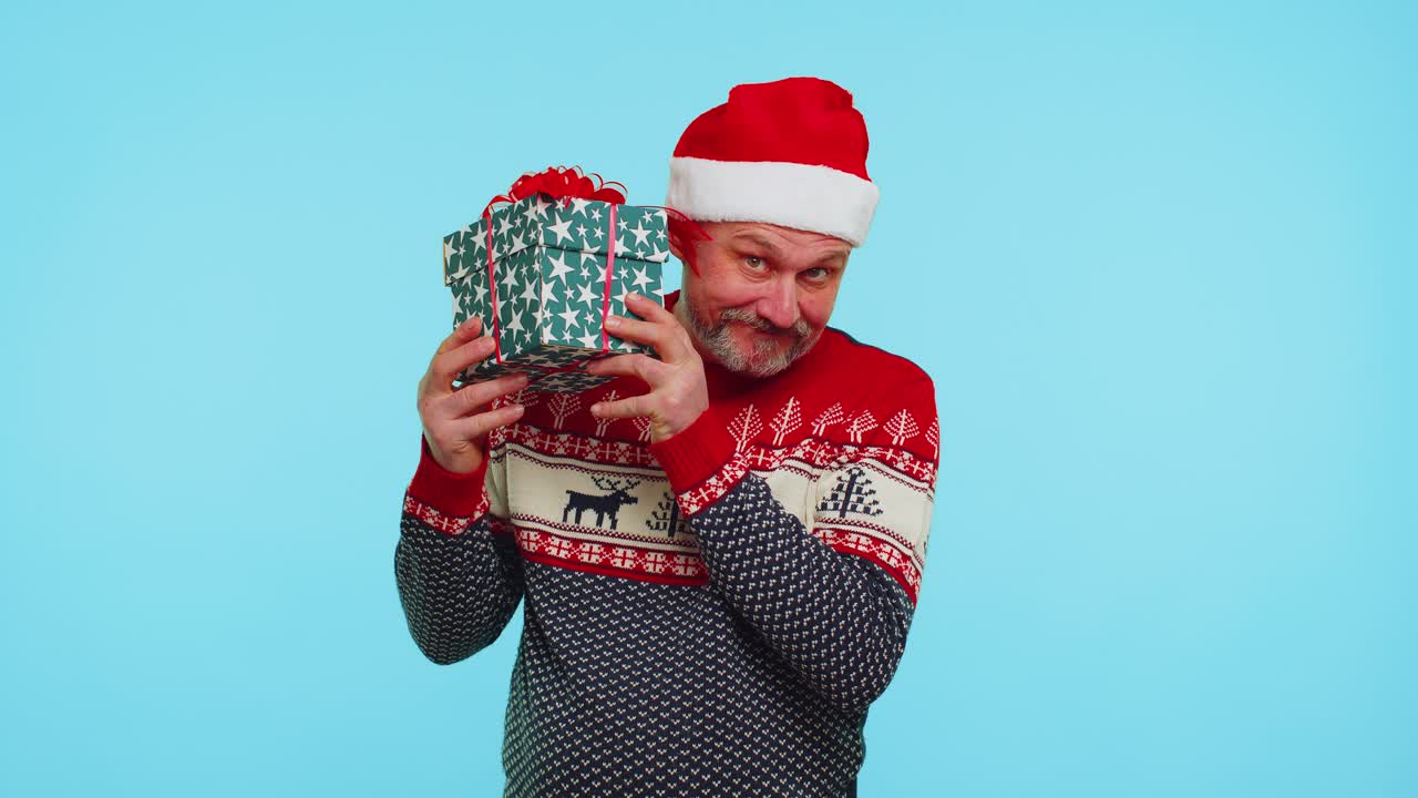 Funny man wears christmas sweater with deers received present interested in what inside gift box