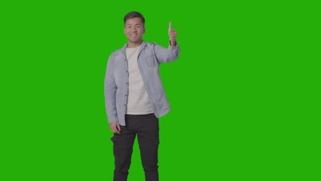 Studio-Shot-Of-Casually-Dressed-Young-Man-Giving-Thumbs-Up-Gesture-Against-Green-Screen-3