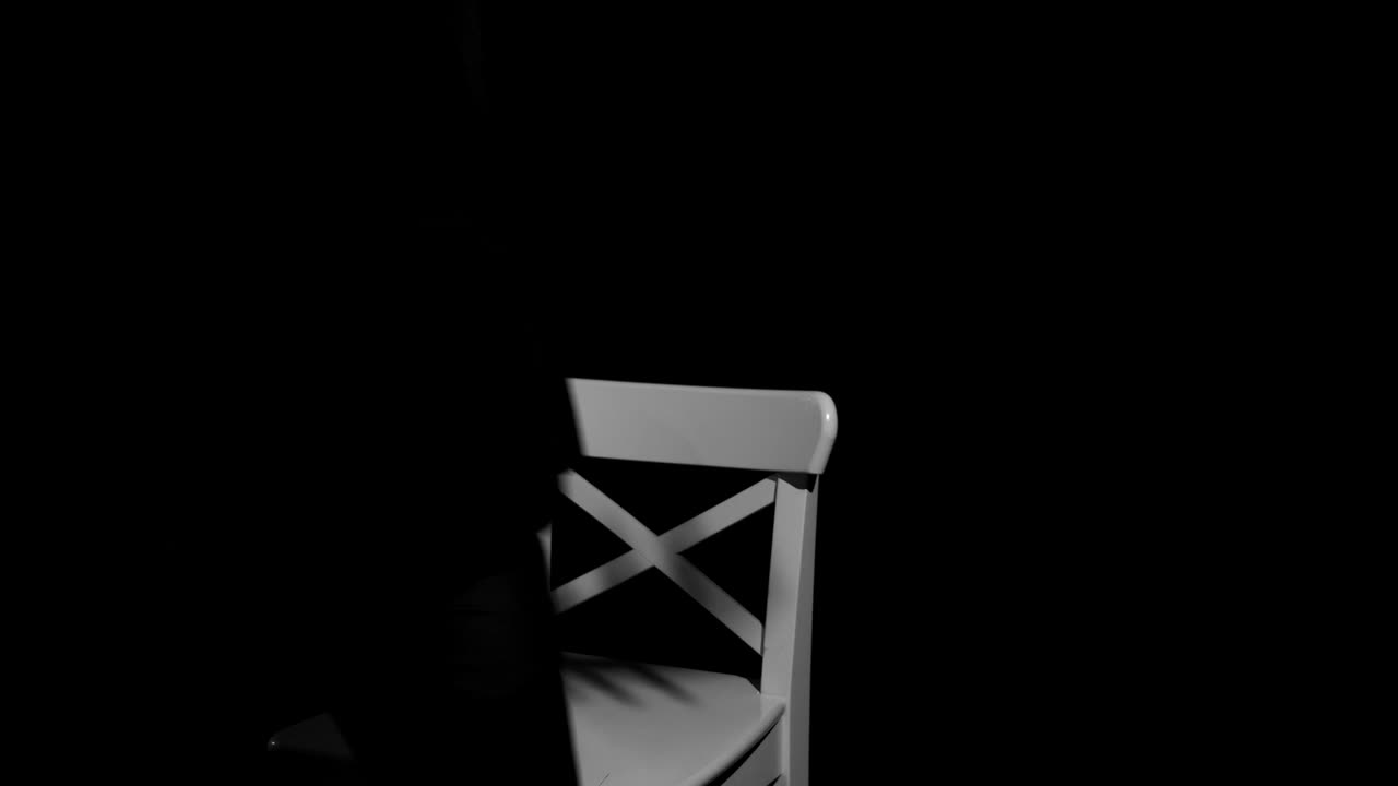 violín blanco en una silla blanca sobre un fondo negro