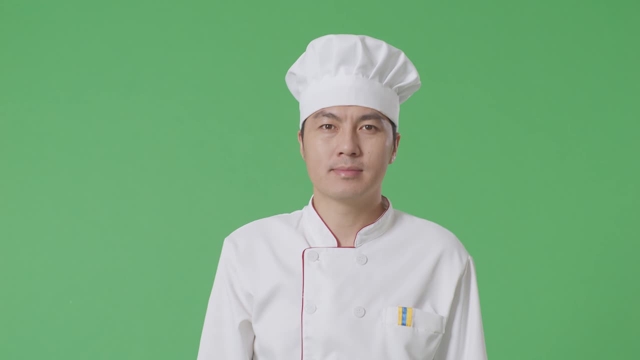 Homem chef asiático caminhando em estúdio com fundo de tela verde