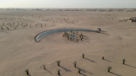 drone view of the moon lake in dubai, moon shape lake is in the middle of al qudra desert, surrounded by golden sand dunes in the united arab emirates