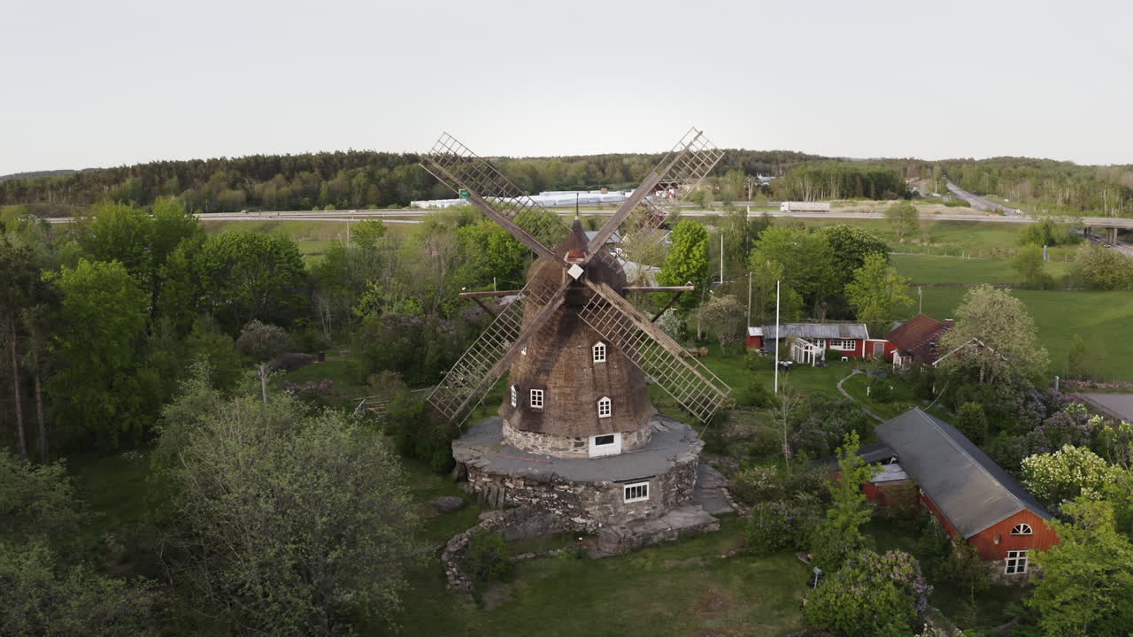 Wide aerial Drone shot moving towards Sunvära kvarn Museum and windmill in Sweden.