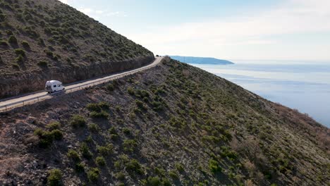 autocaravana, conduciendo por un camino sinuoso, entre montañas y mar, cres, croacia