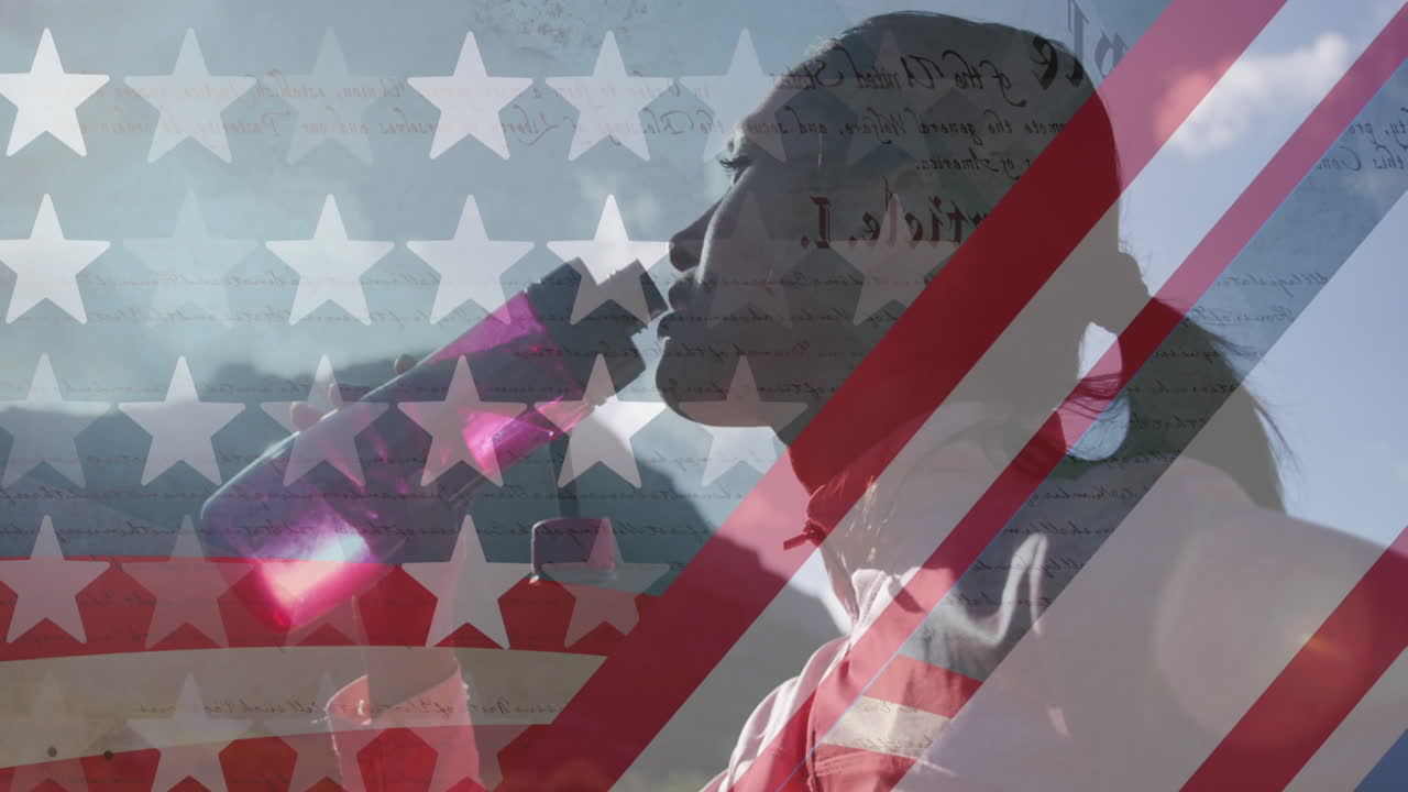 Animation of american flag over biracial woman drinking water in mountains