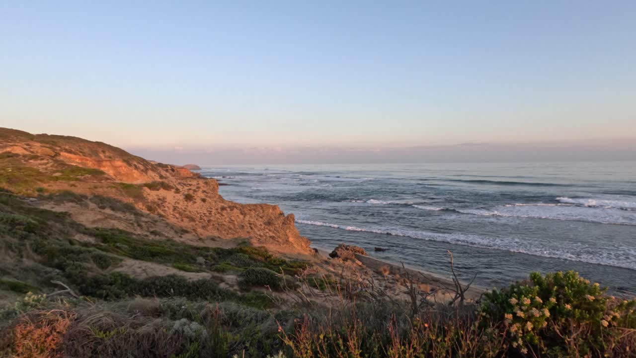 las olas chocando contra la costa rocosa al atardecer