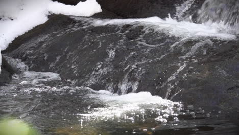 cerca de refrescante agua de derretimiento glacial que fluye sobre una roca en cámara lenta