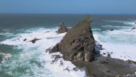 Aerial-view-of-huge-coral-rock-hits-by-the-waves-on-Watu-Lumbung-Beach---Yogyakarta,-Indonesia