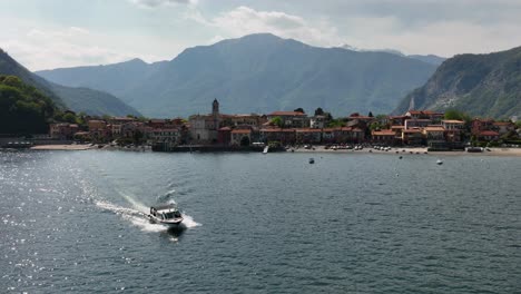 estableciendo una hermosa toma de dron del ferry en el lago lago maggiore con la ciudad al fondo