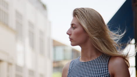 businesswoman standing on city street on commute to work