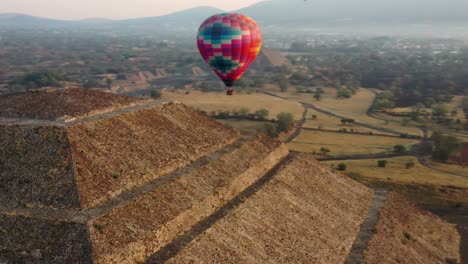 vista aérea del colorido globo aerostático volando sobre la pirámide de la cultura azteca en teotihucan méxico durante el amanecer, 4k