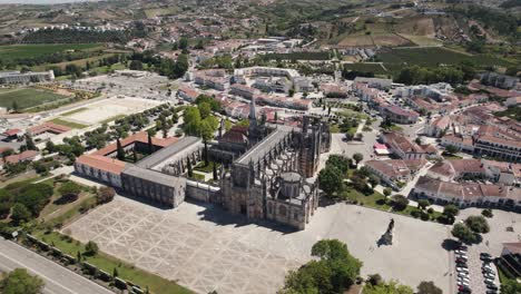 Aerial-pull-out-shot-away-from-the-most-impressive-religious-buildings-of-Portugal,-the-Batalha-Monastery