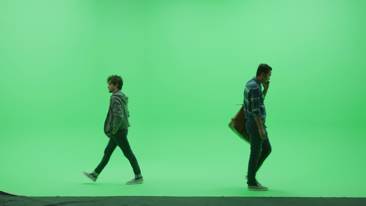 초록색 스크린 스튜디오: 두 명의 젊은 잘생긴 친구가 만나고, 손을 잡고 서로 인사를 하고, 크로마 키 을 가로질러 각자의 길을 습니다.