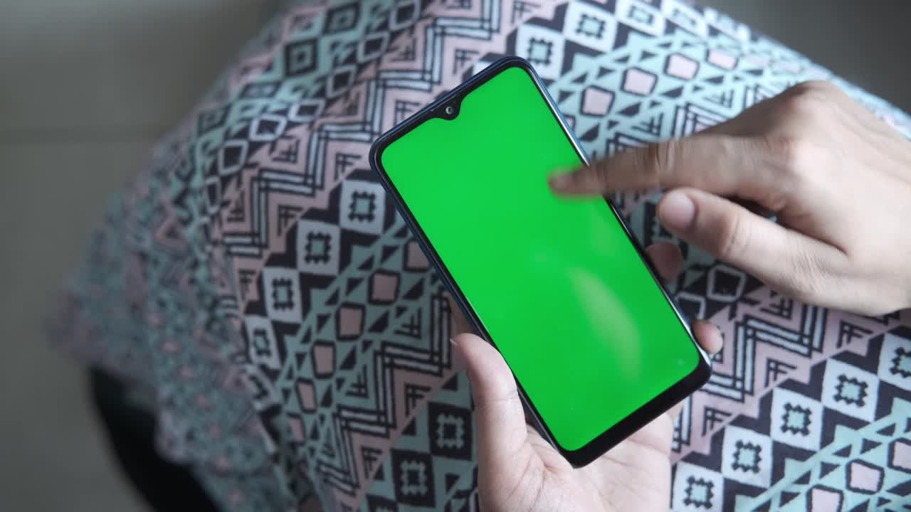 mujer sosteniendo un teléfono inteligente con una pantalla verde