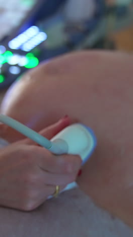 modern ultrasound machine with multiple light buttons. doctor quickly pressing the keys at apparatus while moves the device in other hand on pregnant belly. vertical video