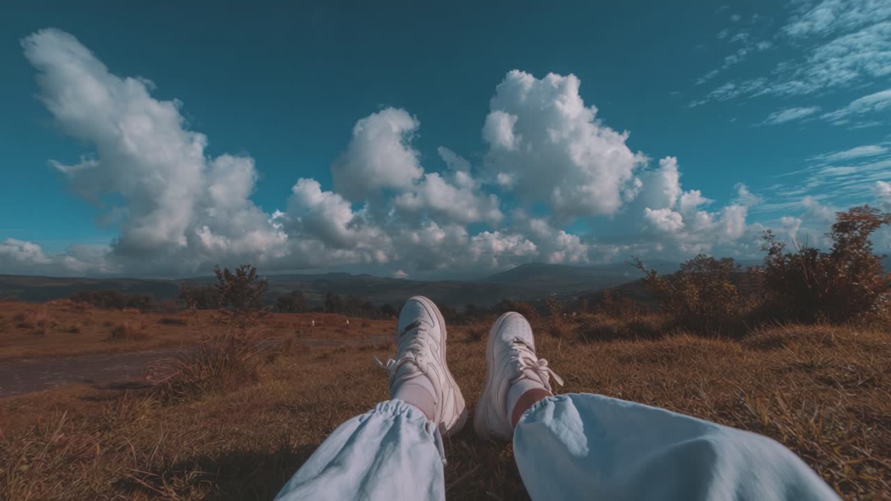 A Serene Escape: Enjoying a Peaceful Moment in Nature with Beautiful Cloudy Skies and Scenic Landscape Beneath My Feet
