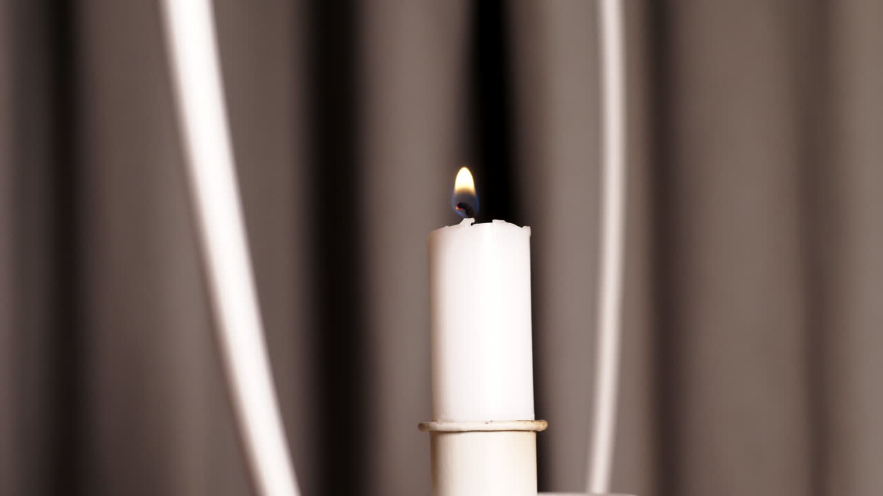 Inquadratura suggestiva di una mano che accende una candela. Primo piano.