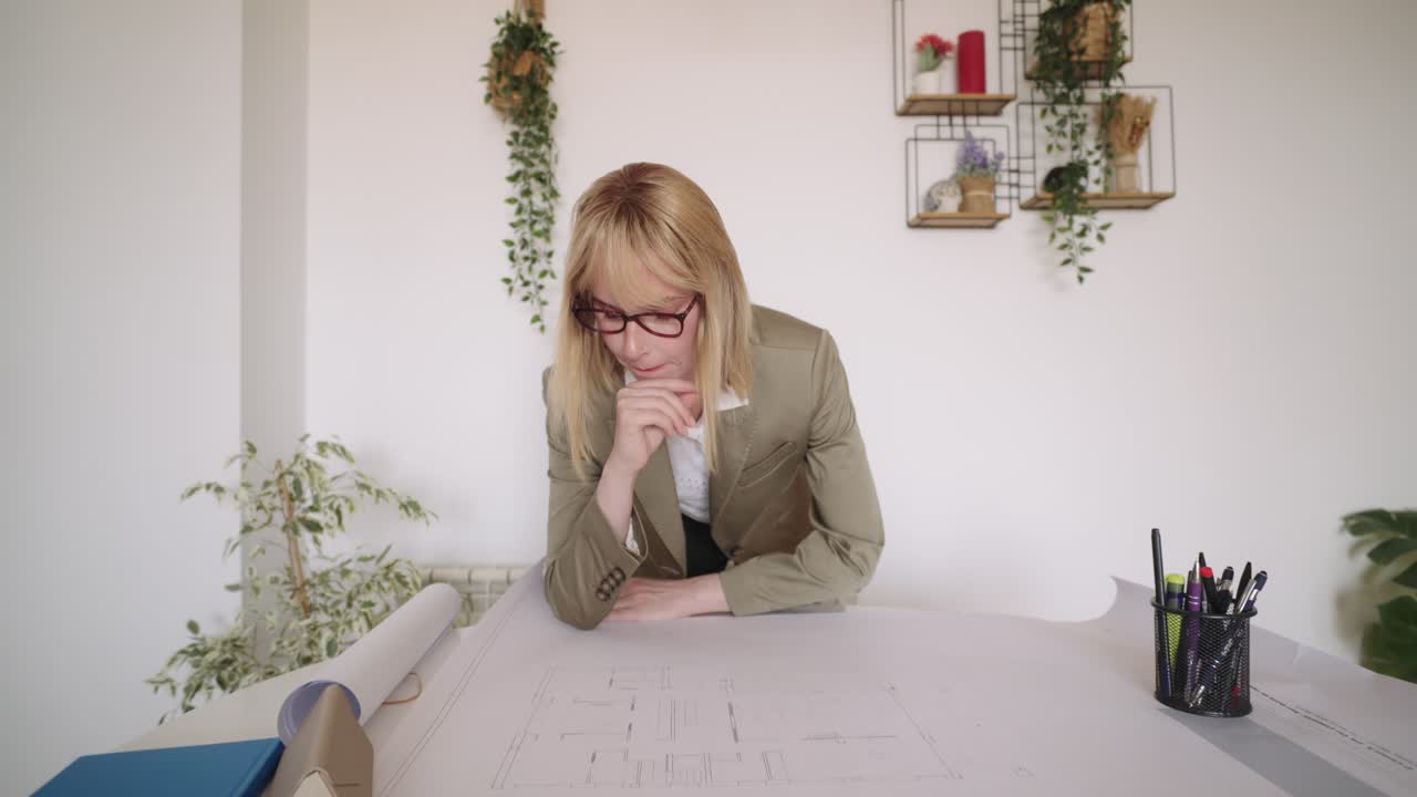 Architect reviewing blueprints at a table