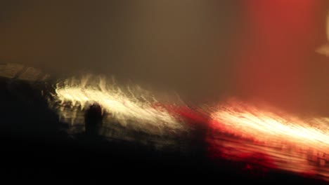 abstract colorful bokeh lights coming from highway road lights, feverish rainy night while driving during storm in 4k