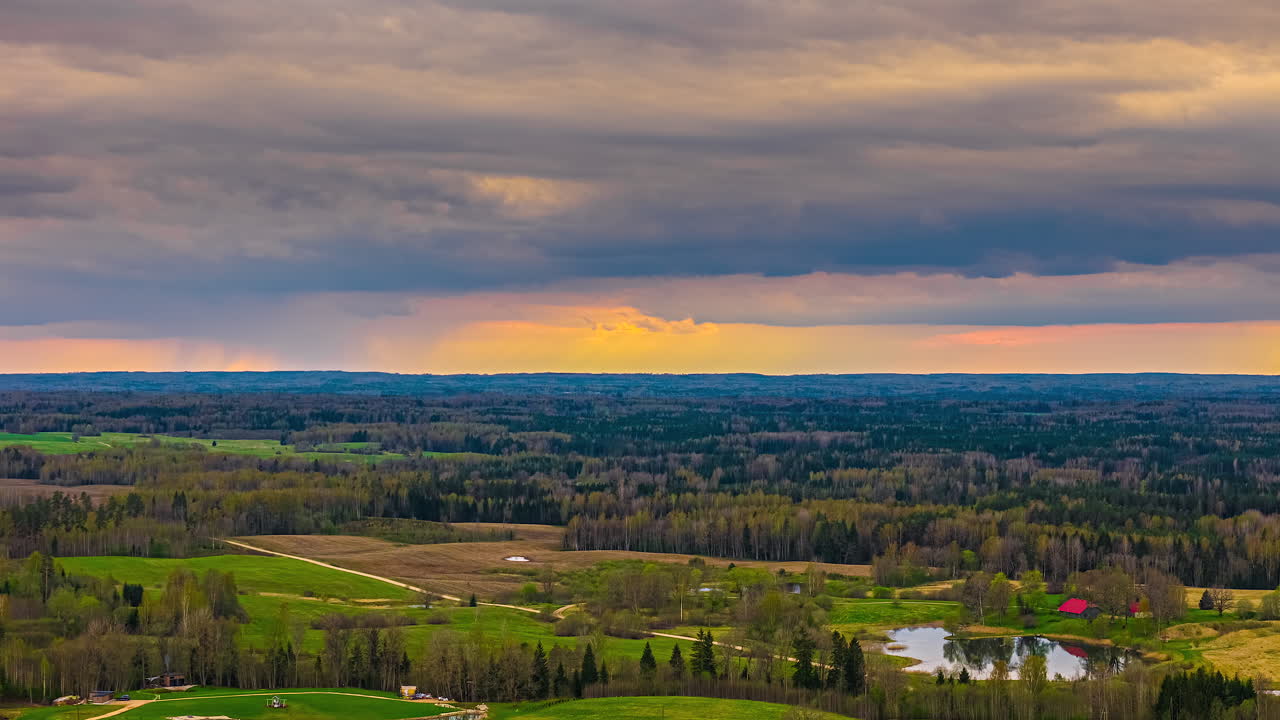 Timelapse of vivid orange sunset horizon fades into blue over silhouettes, dramatic dusk