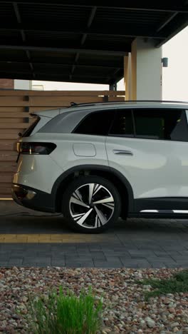 man charging an electric suv at a parking spot