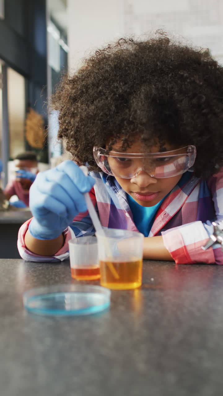Vertical video of diverse schoolchildren at desks in school classroom