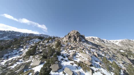 Spectacular-aerial-fpv-drone-shot-over-rocky-mountain-in-sunny-day