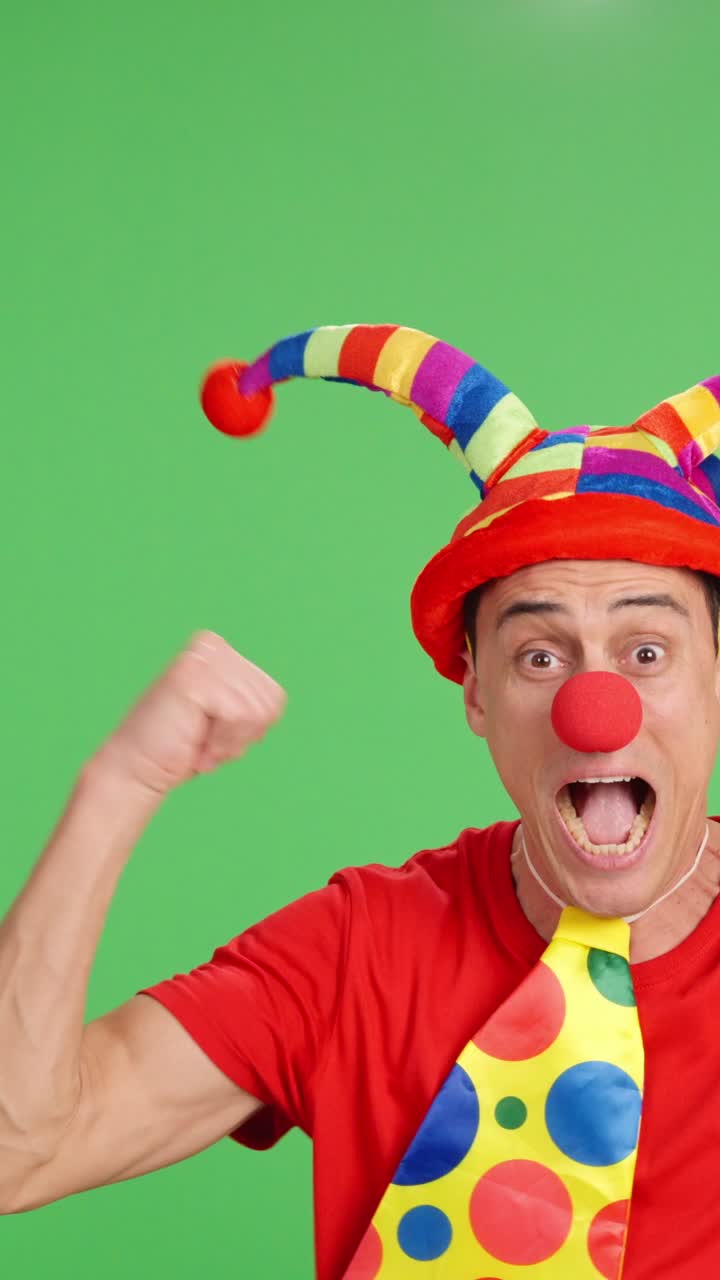 Euphoric clown pointing and showing on green chroma key background
