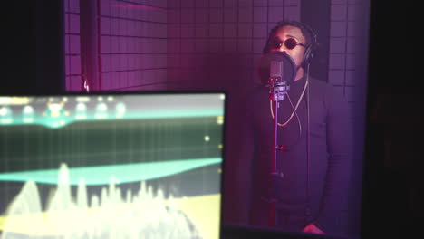 man singing into a microphone in a recording studio