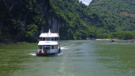 sightseeing boat full of tourists departing on a trip on the magnificent li river from guilin to yangshuo, china