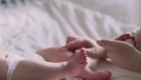 mother applying moisturizing balm on baby's feet