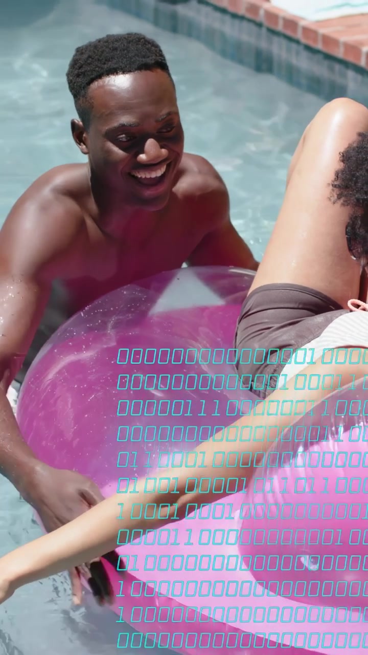 Vertical video: Man steadying pink ring in pool to help pal settle, tech overlay appearing above