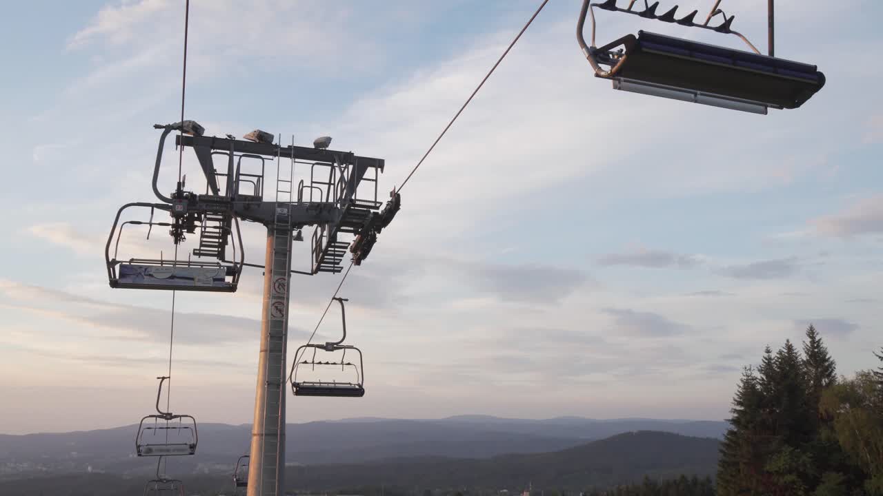 Closed ski lift in the summer, low angle shot with panorama background, man walking down