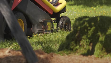 Gardener-preparing-lawn-mower-with-dirty-rubber-shoes,-handheld-view