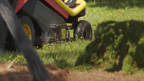 gardener preparing lawn mower with dirty rubber shoes, handheld view