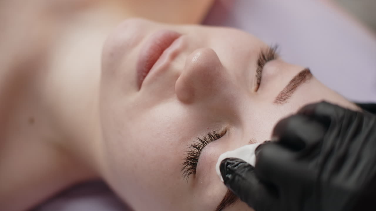 Woman receiving eyebrow treatment at a beauty salon