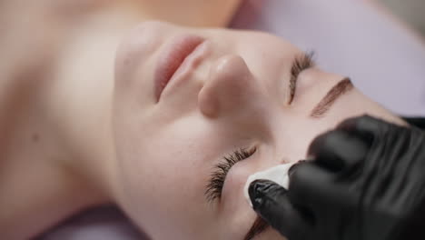 woman receiving eyebrow treatment at a beauty salon